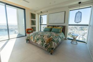 a bedroom with a bed and large windows at Oasis on the 27th, Mercury Tower in St Julian's +26 photos