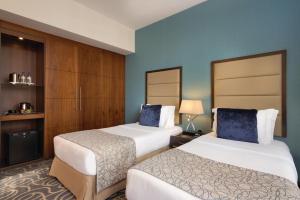 Voodi või voodid majutusasutuse Ramada Abu Dhabi Corniche toas