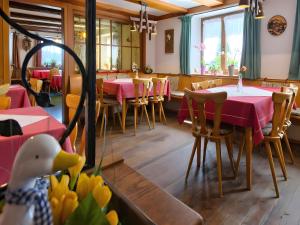 a restaurant with red tables and chairs and a duck at Gasthaus-pension zum Löwen in Grafenhausen