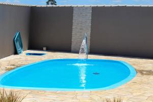 a swimming pool with a fountain in a yard at Canto dos Pássaros in Igarassú