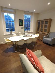 un soggiorno con un tavolo e un divano di West Pallant Georgian Townhouse in City Centre with Courtyards, BBQ & Log Burners - Dogs Welcome! Chichester Holiday Properties a Chichester