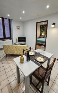 a dining table and chairs in a living room at Appartement au cœur de Marcillac-Vallon in Marcillac-Vallon