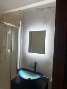 a bathroom with a blue sink and a mirror at Beautiful Apartment in the city center in Belfast