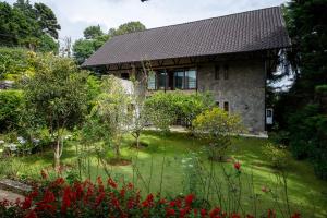 a house with a garden in front of it at Tathya Hills - Luxe Garden Retreat In The Hills in Nuwara Eliya