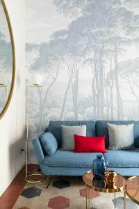 a blue couch in a living room with a tree mural at YCH-Colosseo book house in Rome