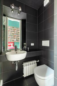 a black bathroom with a sink and a toilet at YCH-Colosseo book house in Rome