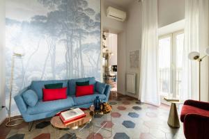 a living room with a blue couch with red pillows at YCH-Colosseo book house in Rome