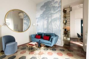 a living room with a blue couch and a mirror at YCH-Colosseo book house in Rome
