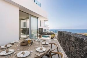 a dining room with a table and a view of the ocean at LuxLiving Tenerife Villa Balansa in Adeje