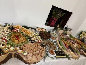 a table topped with lots of different types of food at Pensiunea Silvania in Statiunea Borsa