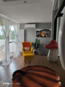 a living room with a yellow chair and a couch at Apartman Lamarti in Samobor +3 photos