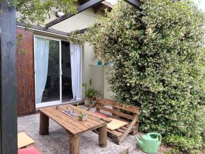 a wooden bench sitting on a patio next to a bush at Loft en Los Acantilados in Mar del Plata