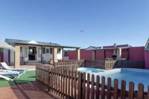 a backyard with a fence and a swimming pool at Bungalow Mis Niñas 2 in Conil de la Frontera