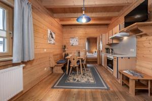 kuchnia z drewnianymi ścianami oraz stołem i krzesłami w obiekcie AUSTRIA APPART - natural Lifestyle Appartements auf der Piste w mieście Obertauern