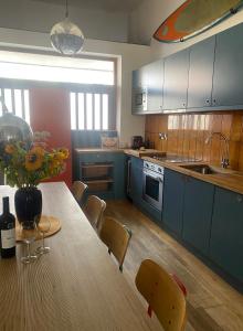 a kitchen with a wooden table with a vase of flowers on it at Eco Friendly beach house in Camber