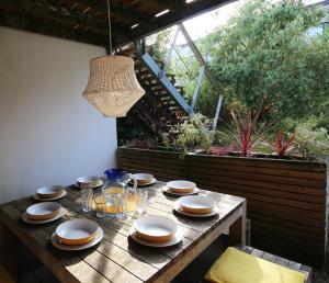 a wooden table with plates and glasses on it at Eco Friendly beach house in Camber