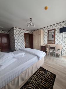 a bedroom with a large bed and a table at Casa Central in Tîrgu Neamţ