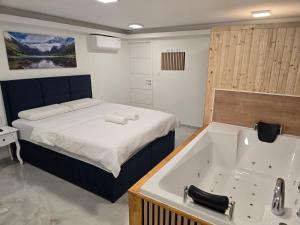 ein Schlafzimmer mit einem Bett und einer Badewanne in der Unterkunft Edy Deluxe Room - Sauna & Jacuzzi in Zagreb