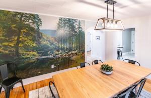 a dining room with a large painting on the wall at White Mountain Escape in Littleton