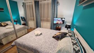 ein Schlafzimmer mit zwei Betten und einem Fernseher in der Unterkunft Apartament Gwiazda przy Stoku na parterze z ogródkiem in Krynica-Zdrój