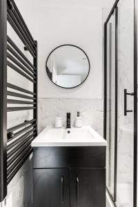 a bathroom with a white sink and a mirror at Sea Breeze Escape in Brighton & Hove