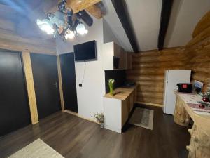 un soggiorno con pareti in legno e pavimenti in legno e una cucina di Cabanele Silvania a Borsa Altre 10 foto