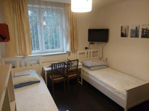 a room with two beds and a table and a tv at Pokoje Hotelowe Noclegi Hotel Pensjonat Venus Siedlce in Siedlce