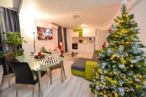 a christmas tree in a living room with a dining table at CityScape Bucharest in Bucharest