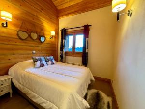 a bedroom with a bed in a room with wooden walls at Chalets d'Angèle D5 - T3 Cosy à Châtel in Châtel