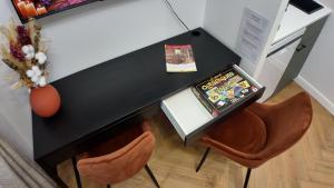 a black desk with two chairs and a vase at Bienvenue à Stella di VAROS in Strasbourg +3 photos