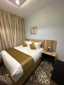 a bedroom with a large bed with white sheets and yellow pillows at Nasamat Hotel in Medina +70 photos