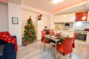 a kitchen with a table and a christmas tree at CityScape Bucharest in Bucharest