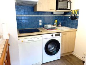 a kitchen with a washing machine and a microwave at Duplex T3 au cœur de Saint-Lary-Soulan - 6 pers., balcon, parking, skis - FR-1-457-130 in Saint-Lary-Soulan +2 photos