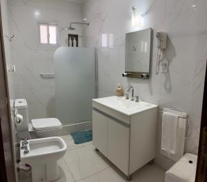 a white bathroom with a sink and a toilet at Like at Home Ezeiza in Ezeiza