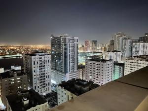 une vue sur les toits d'une ville la nuit dans l'établissement City view furnished room, à Ajman