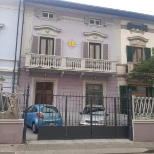 a pink house with two cars parked in front of it at la villa dell'orologio in Santa Croce sullʼ Arno