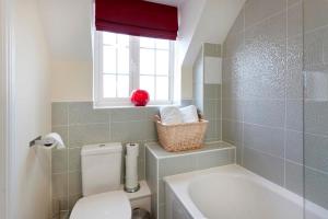 a bathroom with a toilet and a sink and a window at DBS Serviced Apartments - The Twain in Castle Donington +27 photos