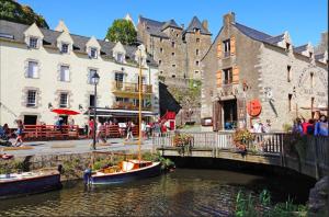a small boat in the water next to a bridge at Charmante maison au calme in Marzan