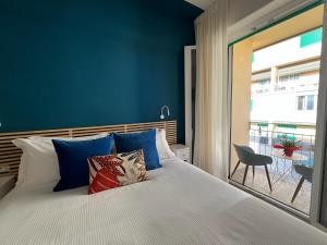 ein Schlafzimmer mit einem Bett mit blauen Wänden und einem Fenster in der Unterkunft Florentia Boutique in Florenz