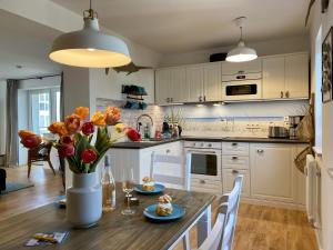 Ferienwohnung Küstenkind im Haus Strandbummler Baabe في بابي: مطبخ مع طاولة خشبية مع إناء من الزهور +13 صورة