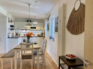 Ferienwohnung Küstenkind im Haus Strandbummler Baabe في بابي: مطبخ وغرفة طعام مع طاولة وكراسي