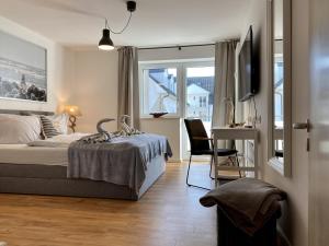 Ferienwohnung Küstenkind im Haus Strandbummler Baabe في بابي: غرفة نوم بها سرير ومكتب وتلفزيون