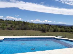 a large swimming pool with a view of a field at Complejo de cabañas- Lomas del Sol in Los Reartes