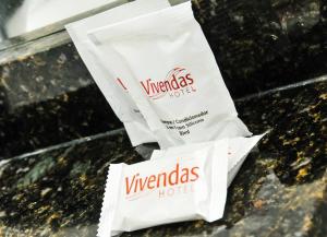 two white bags sitting on top of a counter at Vivendas Hotel in Erechim