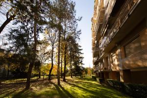 a grass field next to a building with trees at LA TERRAZZA VISTA DUOMO, piscina e campi da tennis in Milan