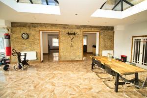 a room with a wooden table and a brick wall at Rochester - Large Private Lounge - Bedroom With En Suite Shower - Large Dining Area - Kitchen - Very Close To Town Centre - Wifi - Off Street Parking in Rochester
