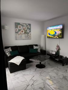 a living room with a black couch and a table at TK OCEANVIEW Apartment in Puerto del Carmen