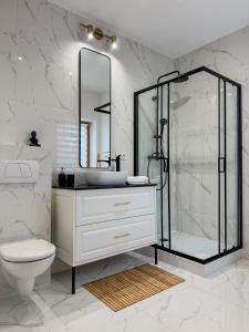 a white bathroom with a shower and a sink at PARKOVA APARTAMENTY - termy, centrum, park in Jelenia Góra