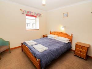 a bedroom with a bed and a chair and a window at Dinas in Pwllheli +9 photos
