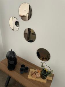 a table with three mirrors on a white wall at Gómez-Tortosa Apartamento in Novelda